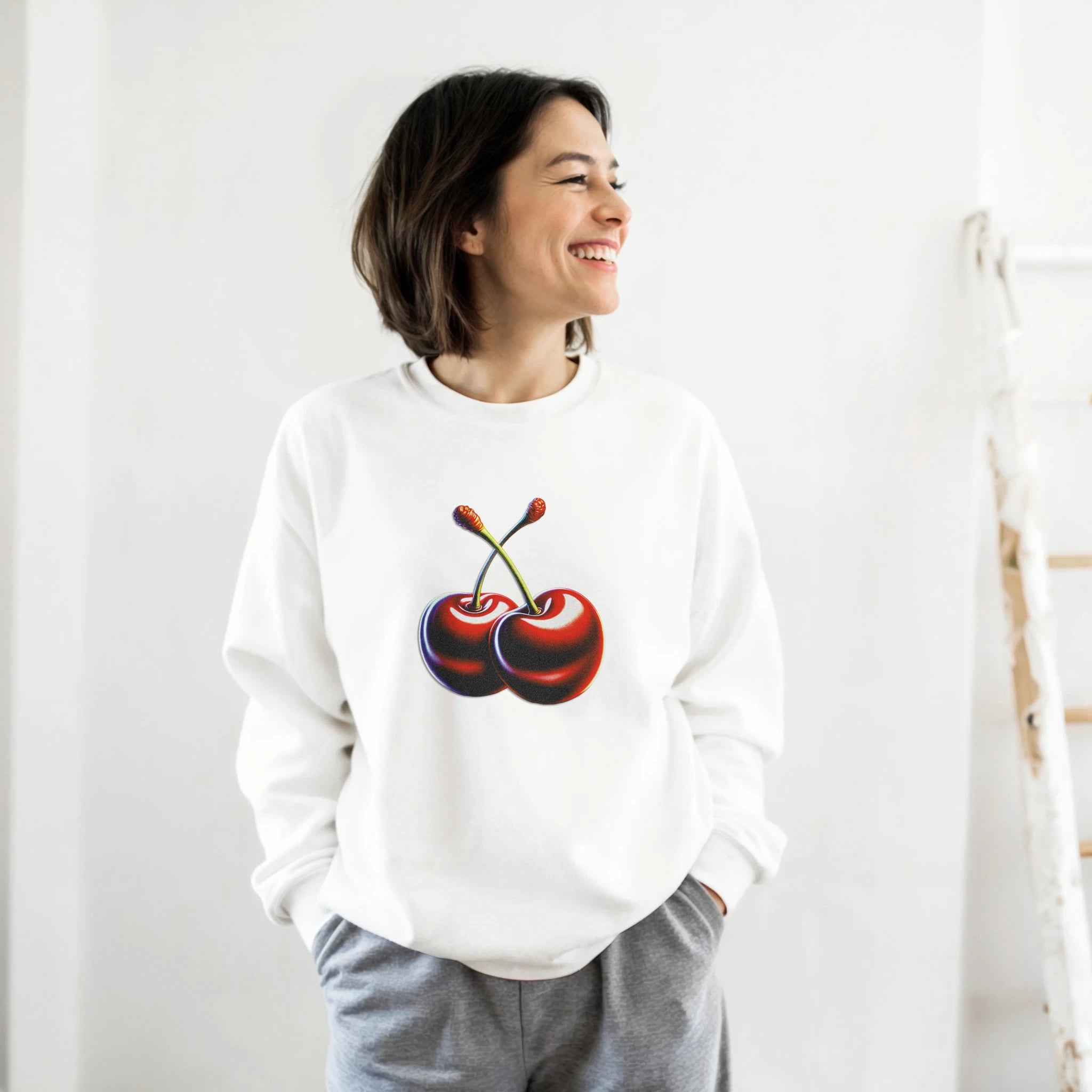 Woman wearing white Cherries Jumper graphic sweatshirt with cherry print; soft cotton-polyester blend.