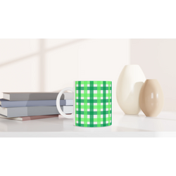 Green gingham ceramic mug with white handle, a cute checkered coffee cup on a desk.