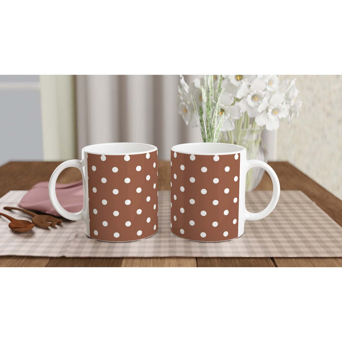 Two brown ceramic mugs with white polka dot pattern sitting on a placemat. Retro spotty coffee cup design for daily use or gifting.