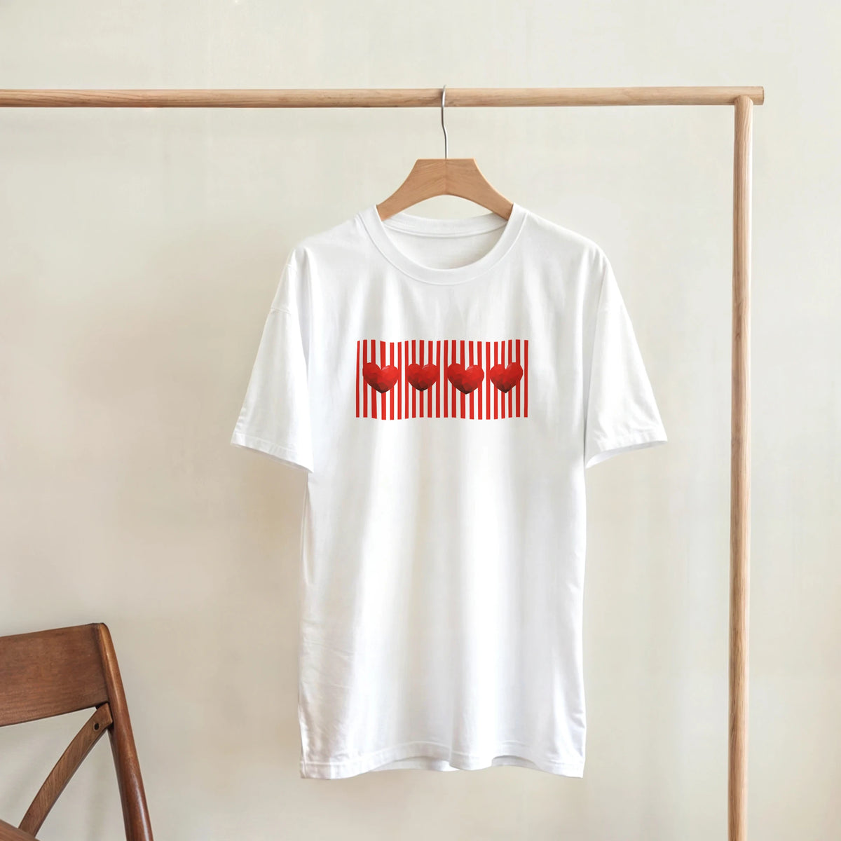 White T-shirt on a wooden hanger featuring a bold red heart graphic with vertical red stripes.