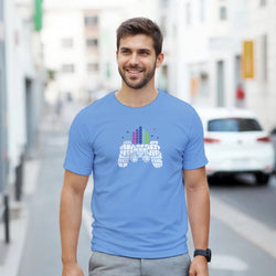 Man wearing light blue retro gamer T-shirt with pixel-art controller and skyline graphic.