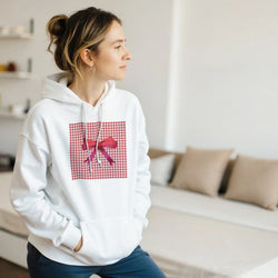 White hoodie featuring a red gingham square print with a pink bow detail, embodying a cute coquette aesthetic.
