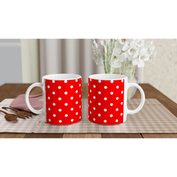 Two red ceramic mugs with white polka dots sit side by side on a checkered placemat, perfect for daily coffee or tea.