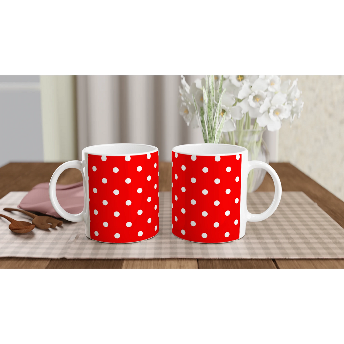 Two red ceramic mugs with white polka dots sit side by side on a checkered placemat, perfect for daily coffee or tea.