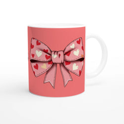 Cute pink and cream coquette bow mug with a heart-pattern bow design for coffee or tea.
