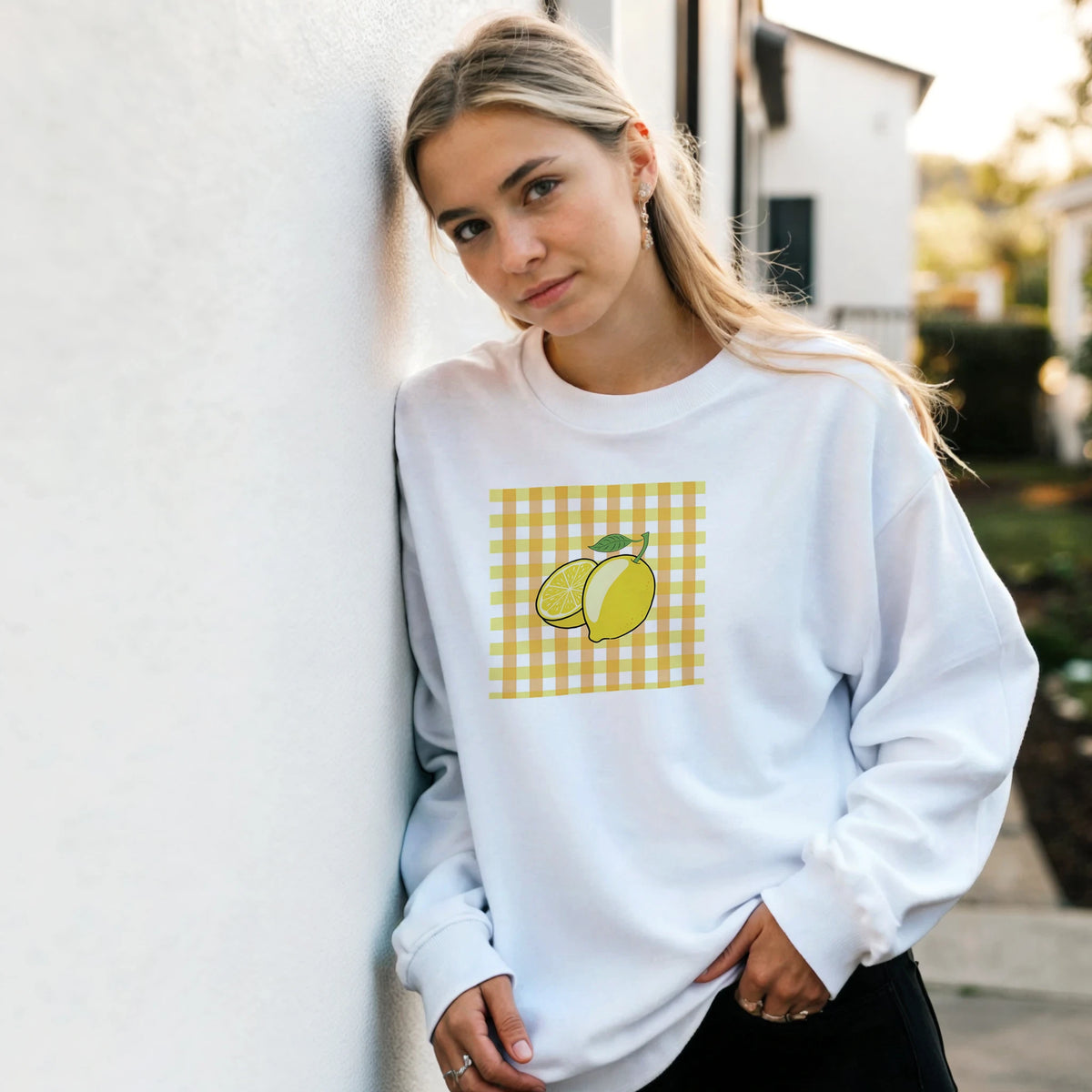 White sweatshirt featuring a retro yellow lemon graphic on a gingham background for a cute vintage fruit aesthetic.