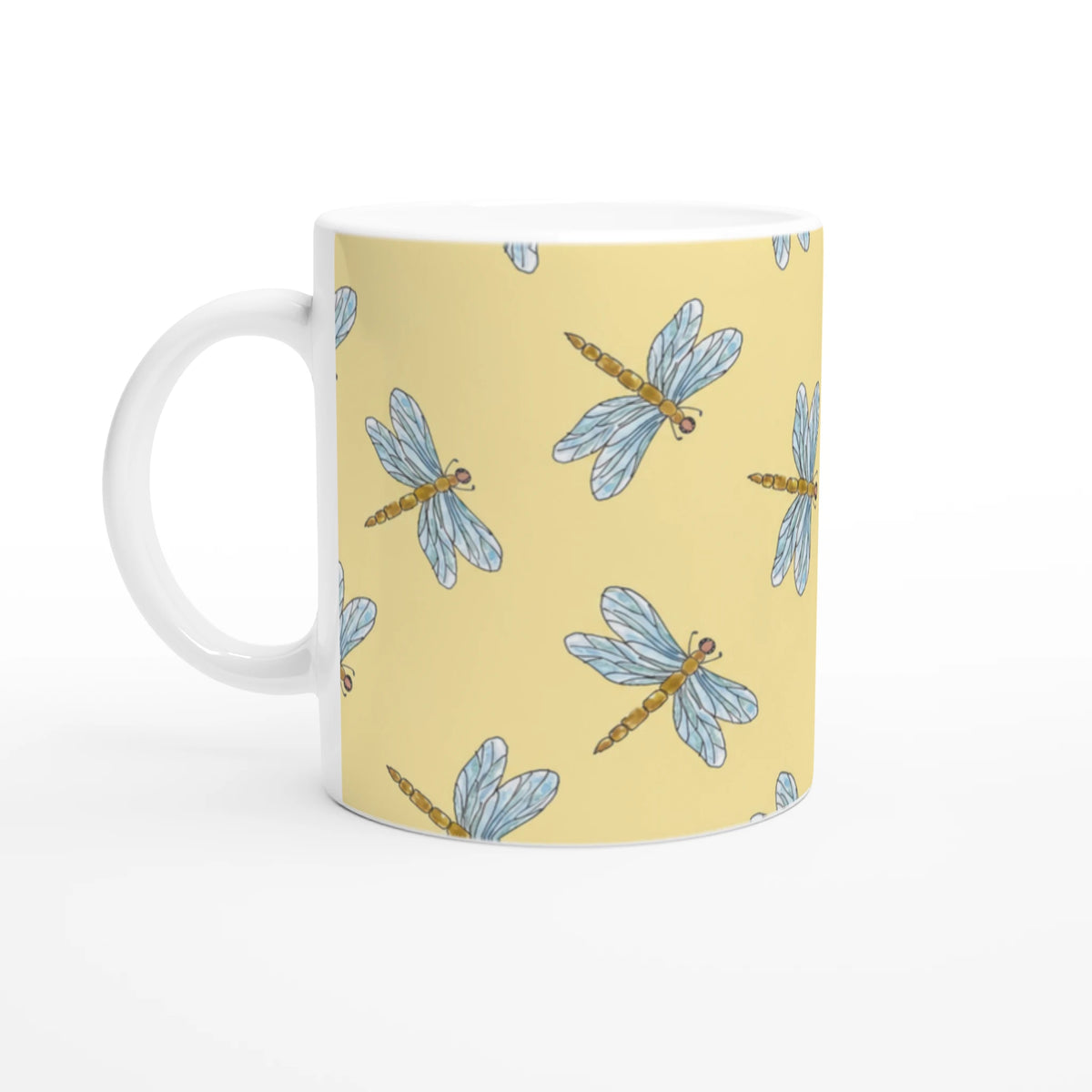 Yellow dragonfly mug with blue dragonflies in a repeating pattern on ceramic coffee cup.