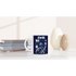 White ceramic mug with navy blue 'It's OK Not To Be OK' slogan and floral design, placed beside books.