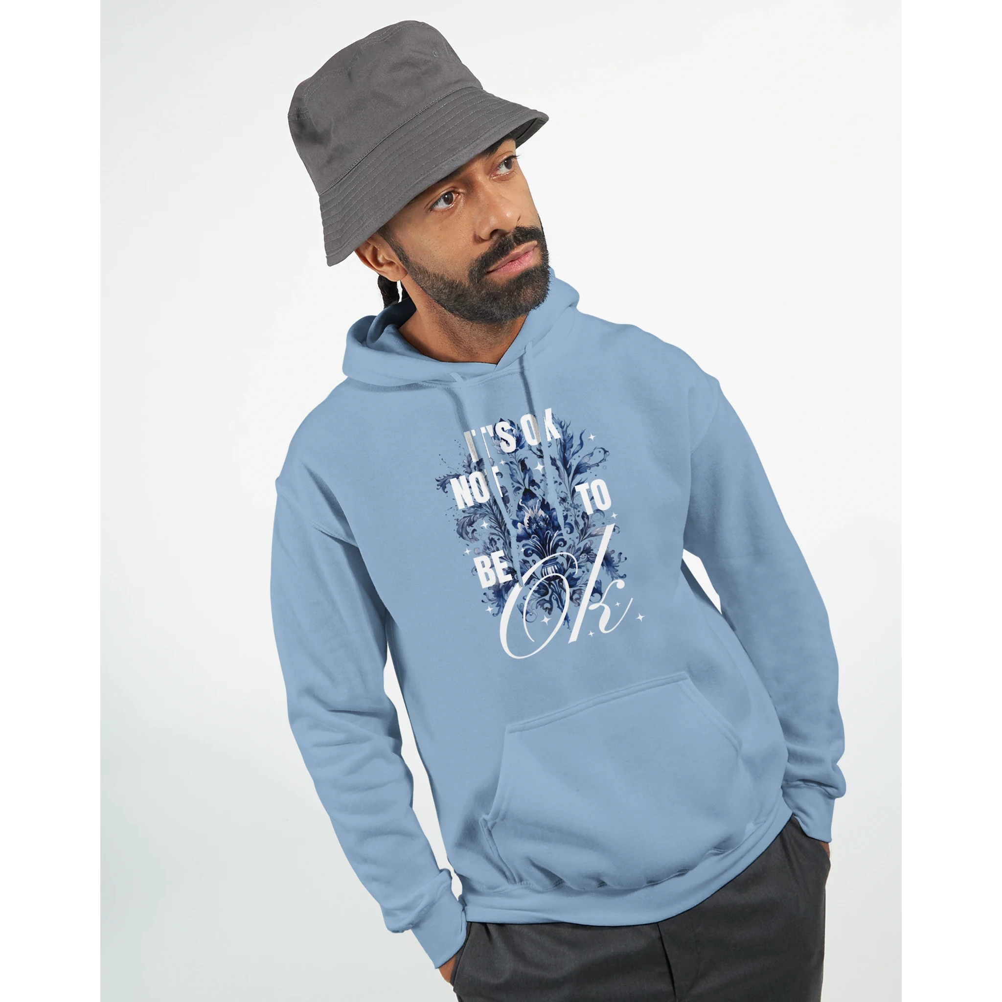 Man wearing light blue cotton blend hoodie with It's OK Not To Be OK floral graphic and front pocket.
