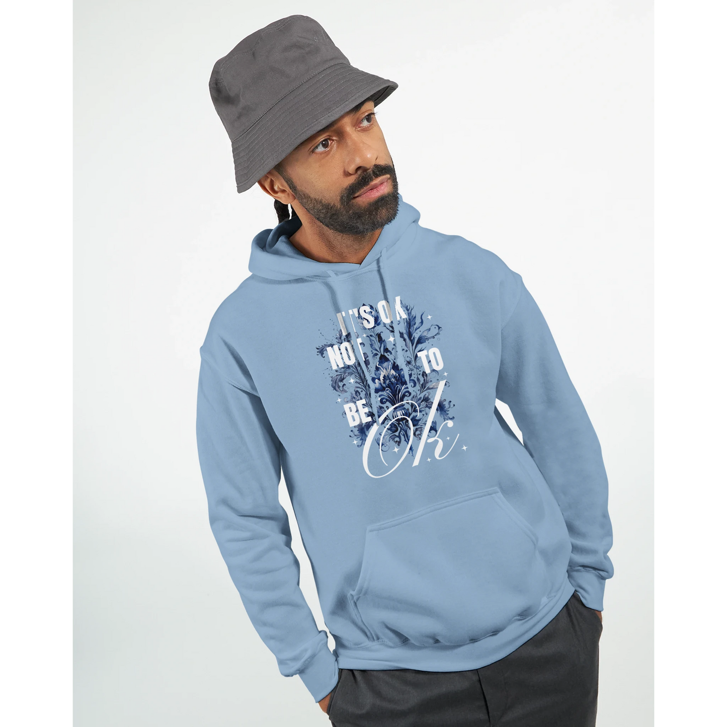 Man wearing light blue cotton blend hoodie with It's OK Not To Be OK floral graphic and front pocket.