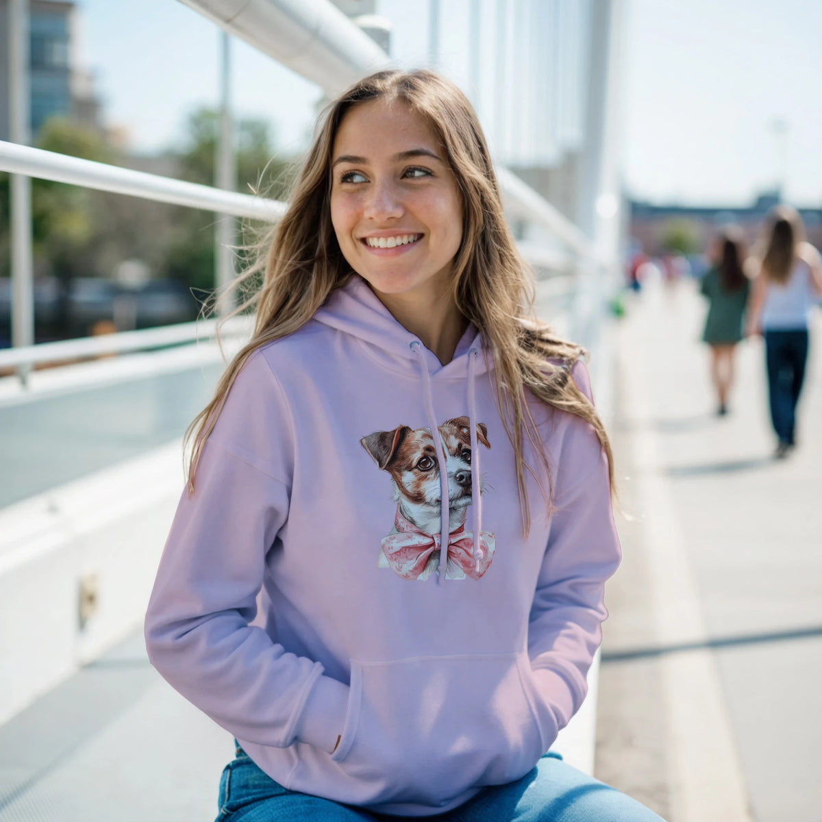Smiling woman in lavender dog-graphic hoodie with pink bow; 50/50 cotton/poly blend, front pouch pocket.