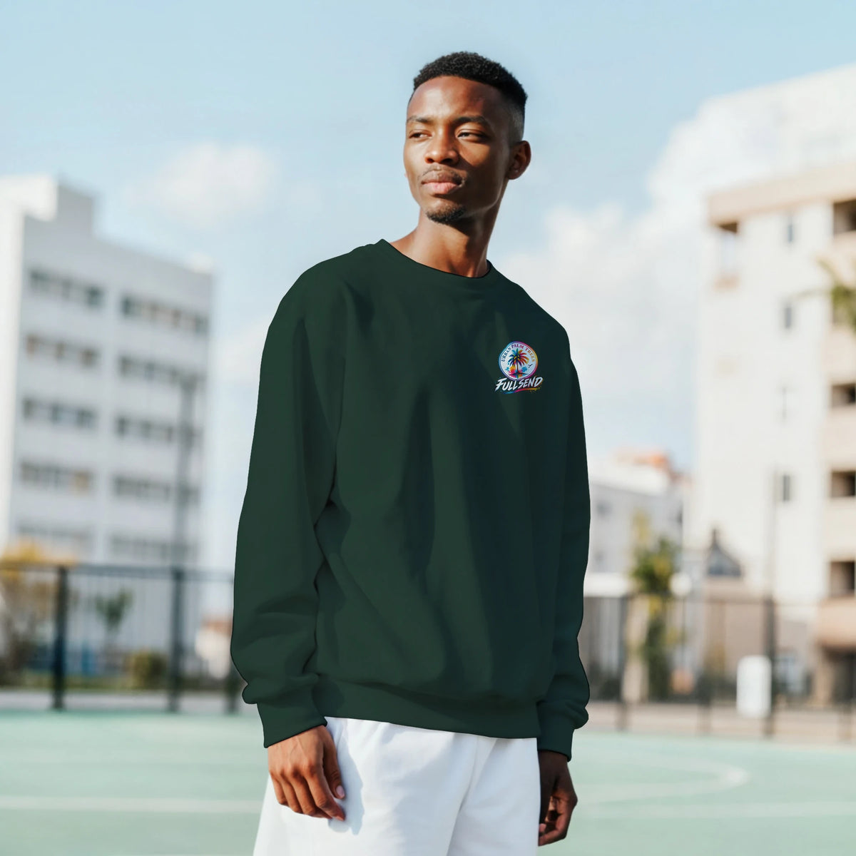 Man wearing dark green Fitment Stance car sweatshirt with small chest logo, styled for petrolhead streetwear look outdoors.