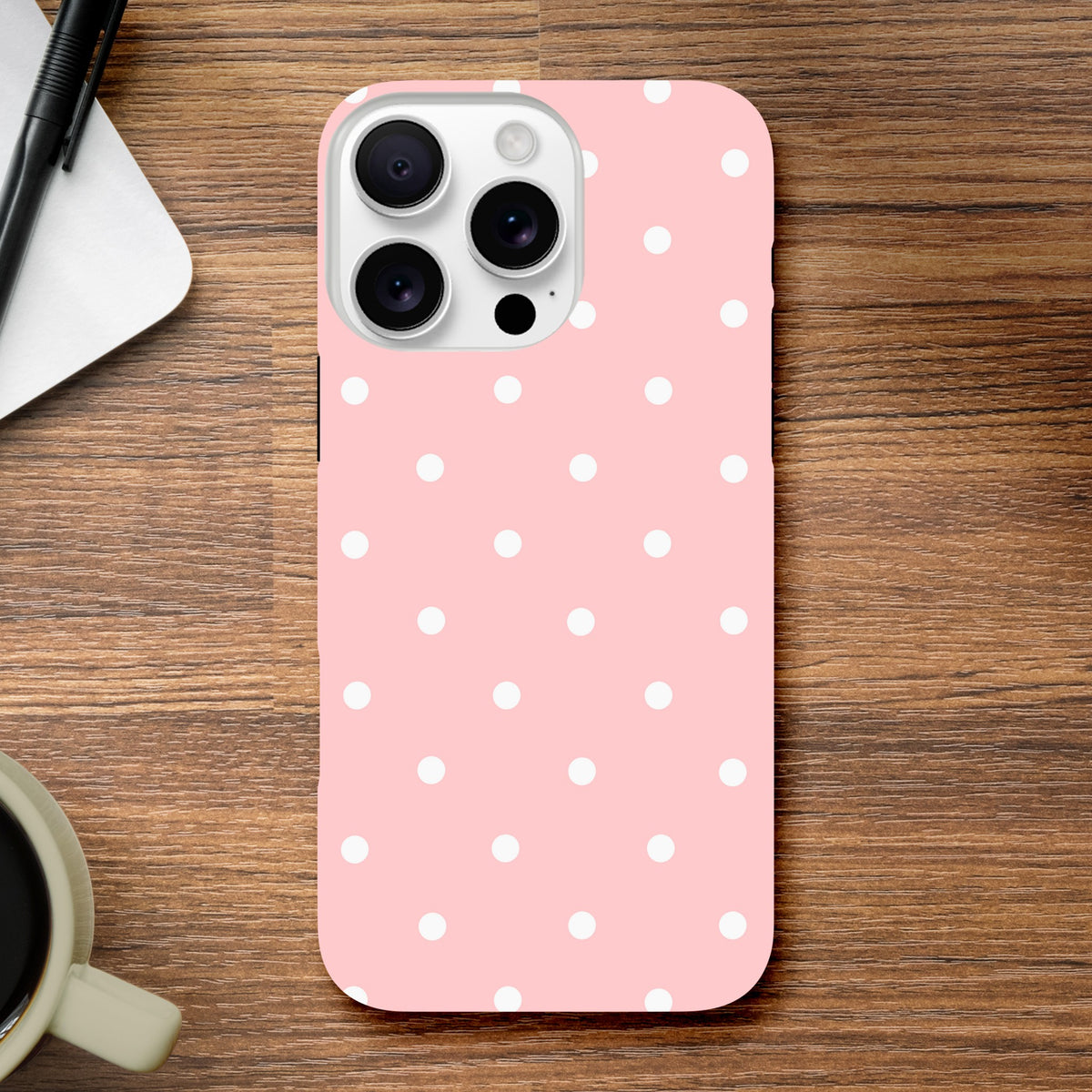 Pastel pink and white polka dot tough iPhone case providing shock-absorbing protection with a cute dual-layer frame.