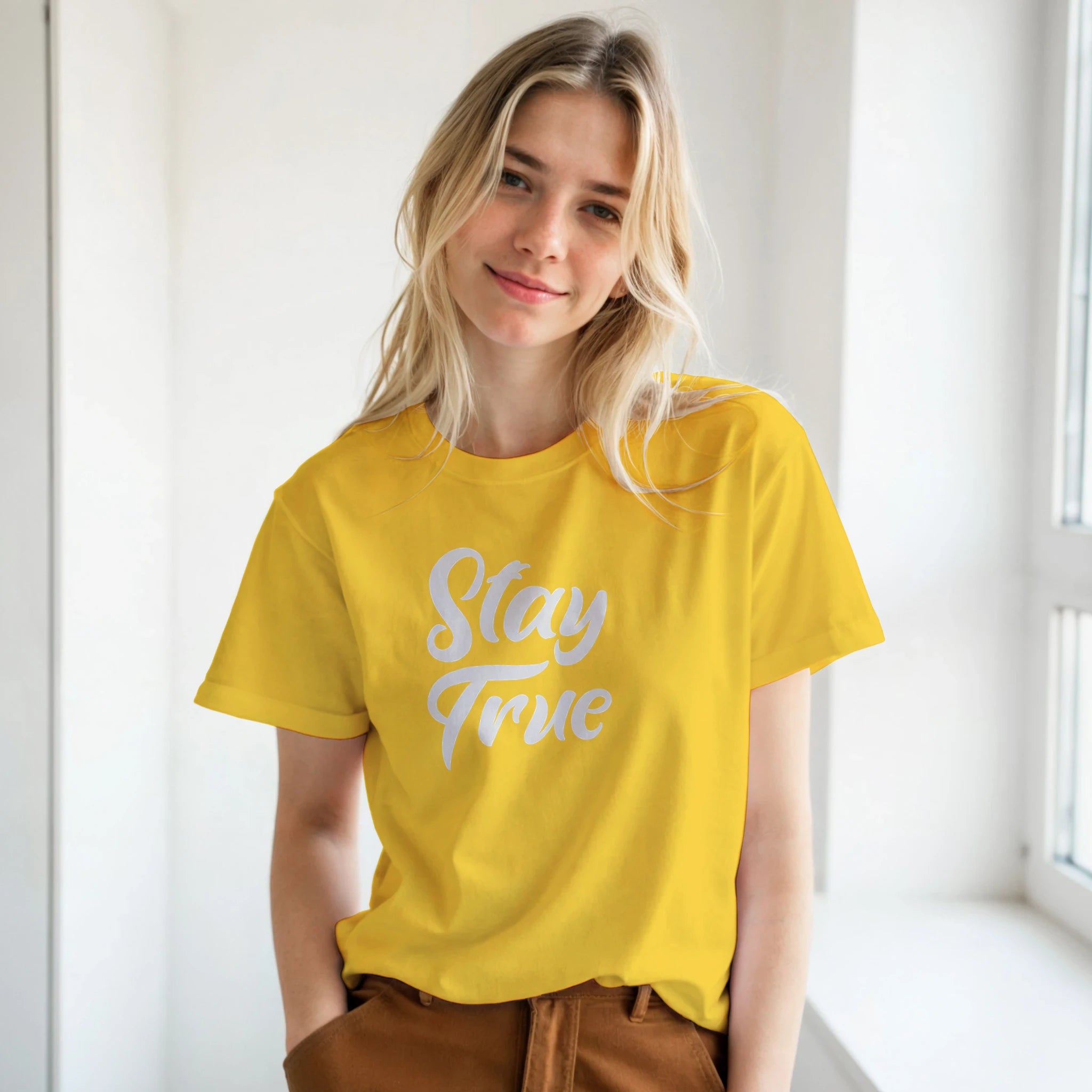 Woman in yellow Stay True T-shirt with white retro slogan, Urban Palm Trees streetwear vibe.