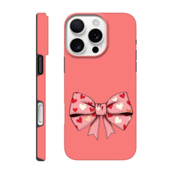 Pink hard phone case featuring a large bow pattern filled with multi-colored hearts for a trendy coquette aesthetic.