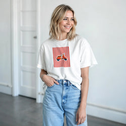 White graphic tee for women featuring a retro orange scooter on red stripes, styled with blue jeans for vintage mod streetwear.