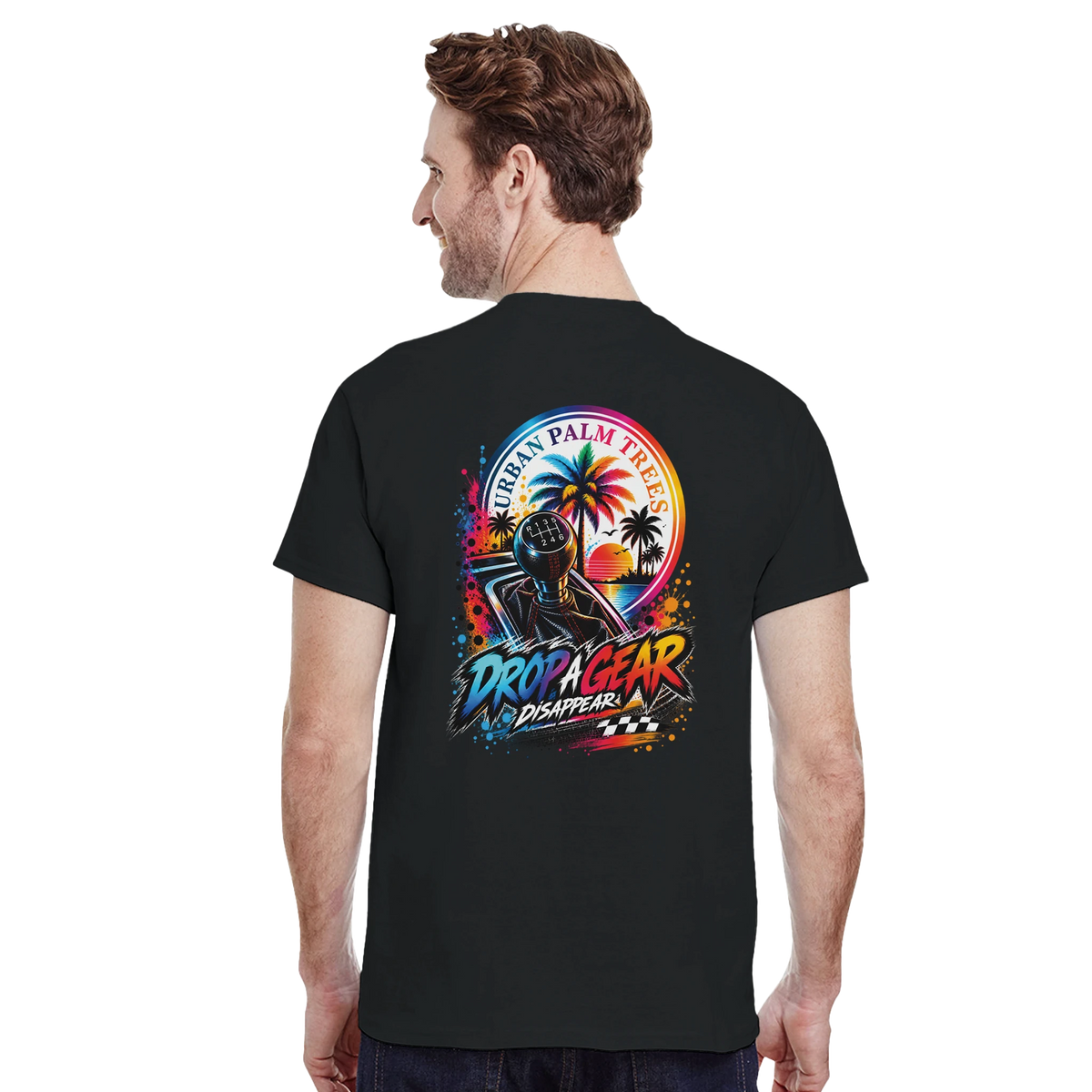 Man wearing black tee with colorful "Drop a Gear Disappear" graphic featuring shift knob, palm trees, and sunset. Modified car culture streetwear.