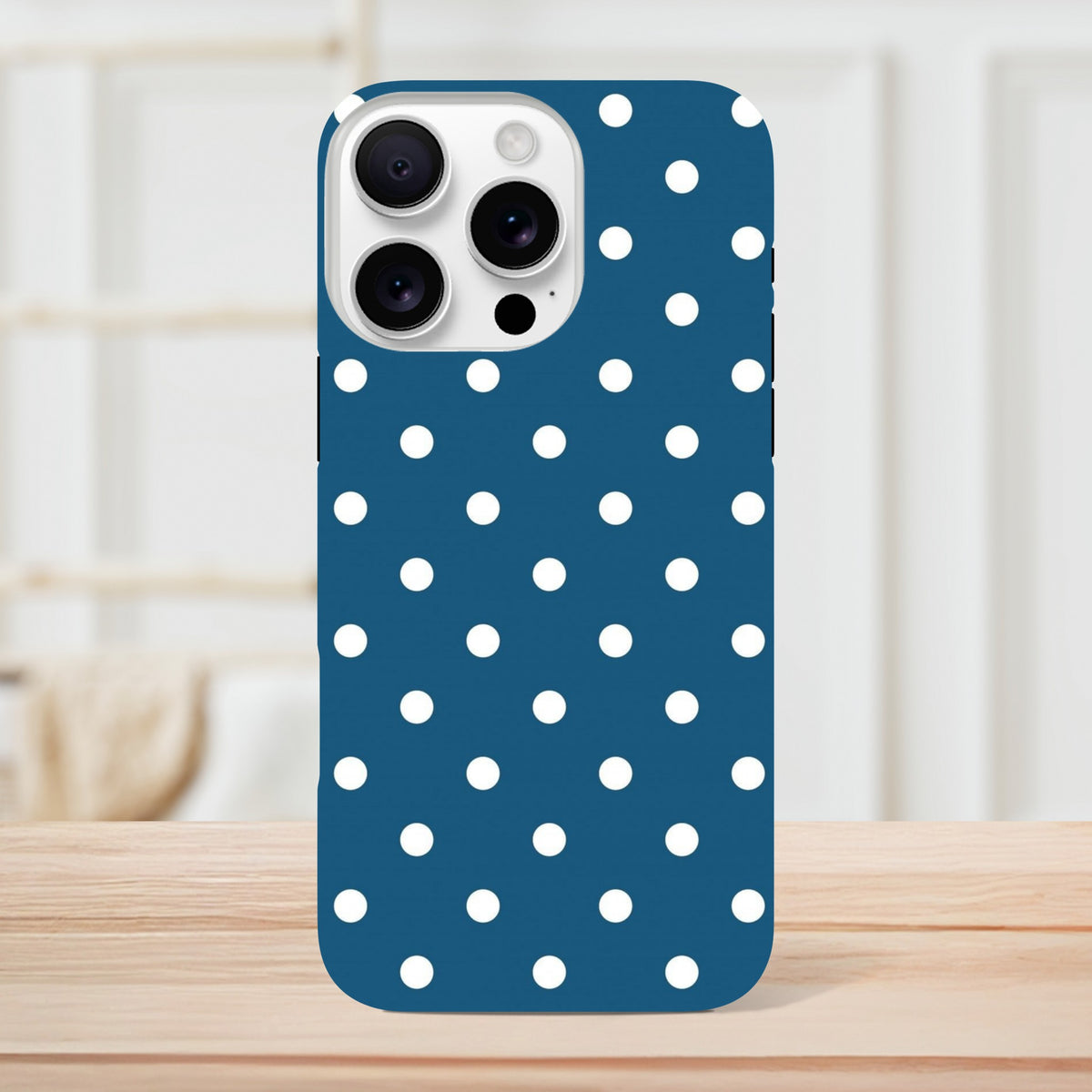 Navy blue iPhone case with white polka dots featuring a glossy finish and precise camera cutout for shock absorption.