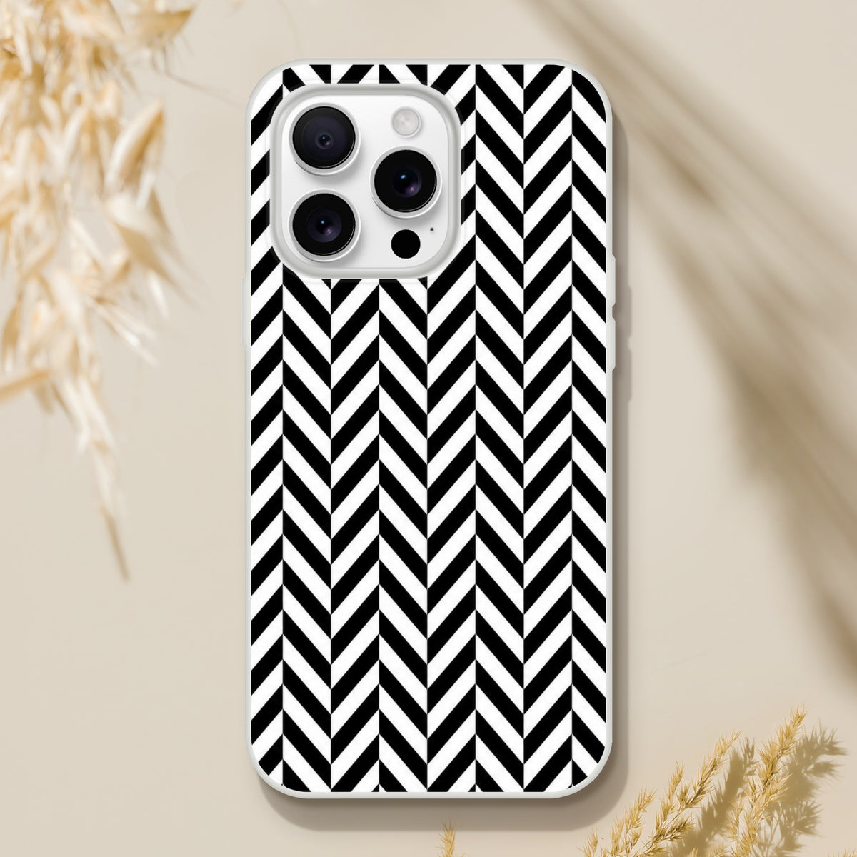 Black and white herringbone iPhone case featuring a bold geometric chevron pattern, designed for shock absorption with a matte finish.