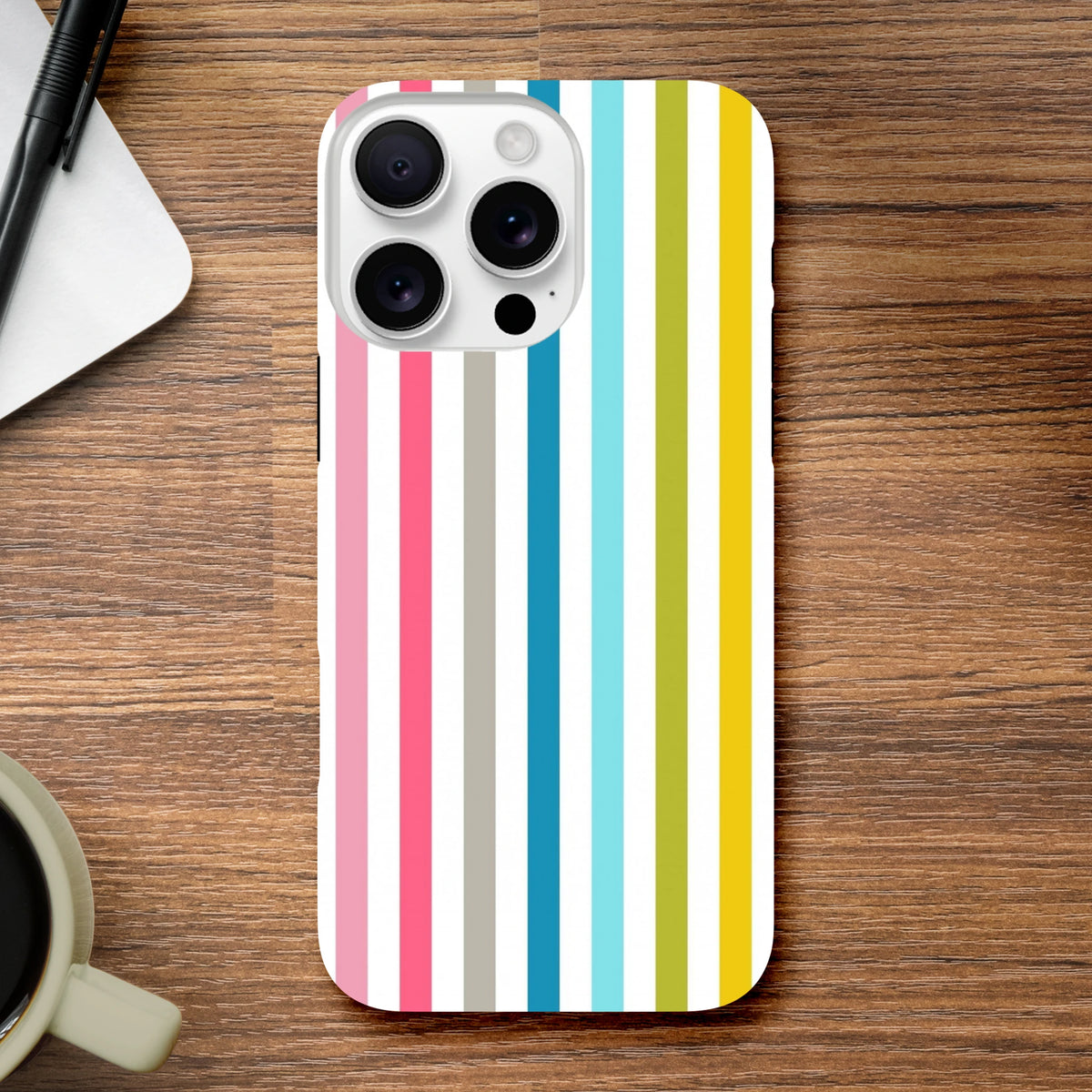 Retro rainbow striped tough iPhone case featuring vertical pink, blue, green, and yellow bands on a wooden desk.