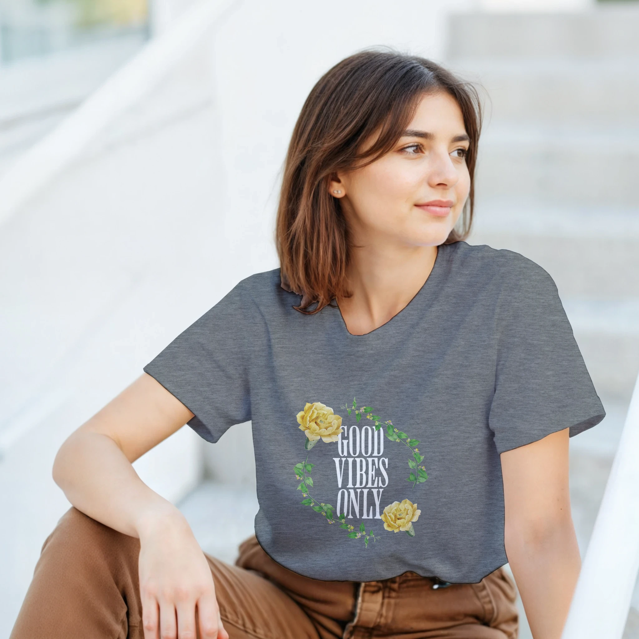 Woman wearing gray Good Vibes Only graphic tee with floral wreath design.