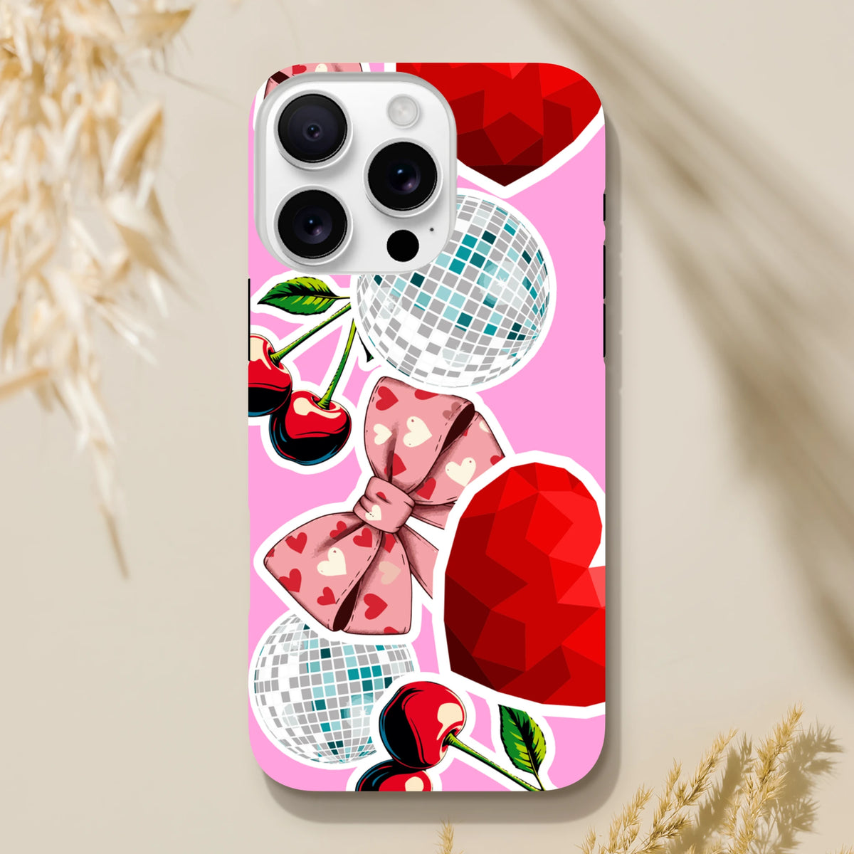 Pink iPhone case featuring Y2K sticker art with cherries, heart bow, disco balls, and red gems for durability and style.