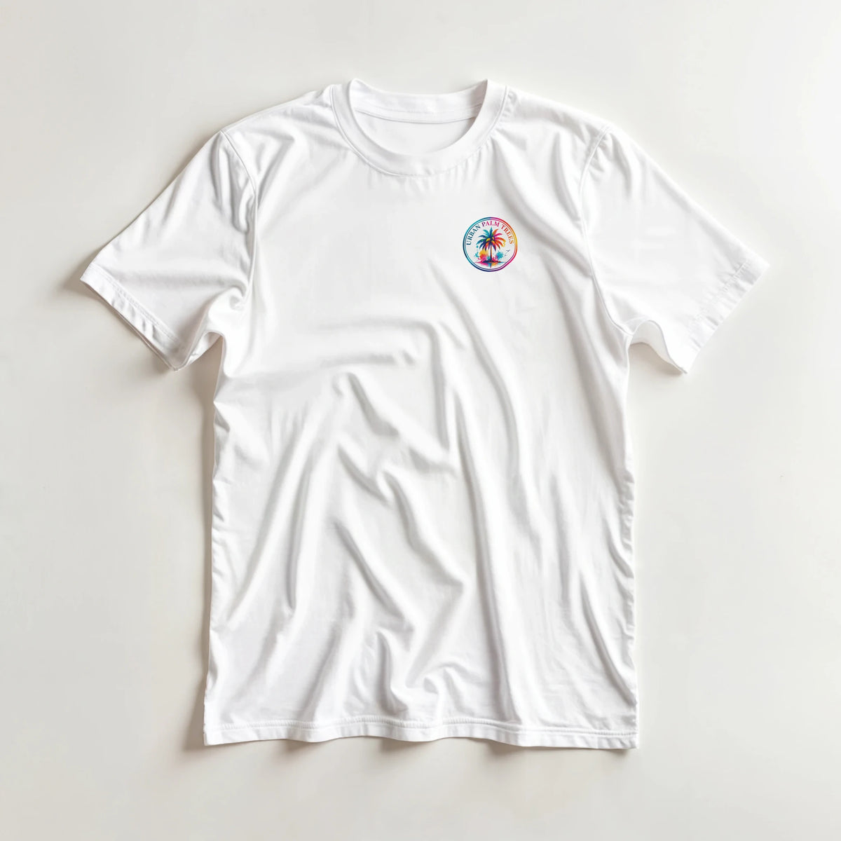 White men's t-shirt featuring a colorful circular Urban Palm Trees logo with a rainbow border and palm tree graphic on the left chest.