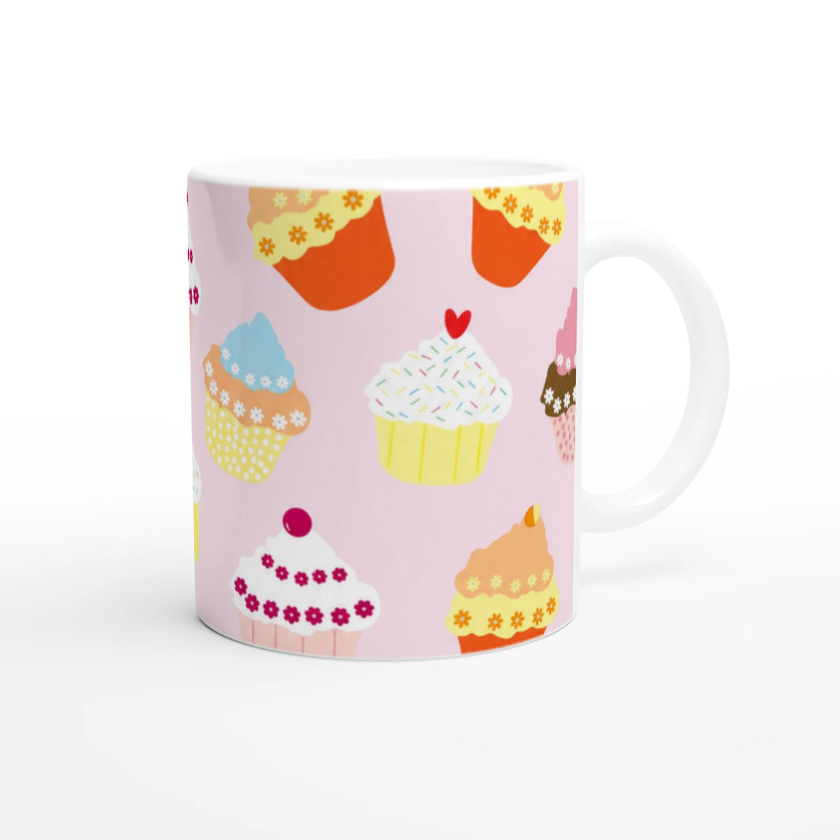 Cute pastel pink cupcake mug with colorful frosting cupcakes pattern on a ceramic coffee cup.