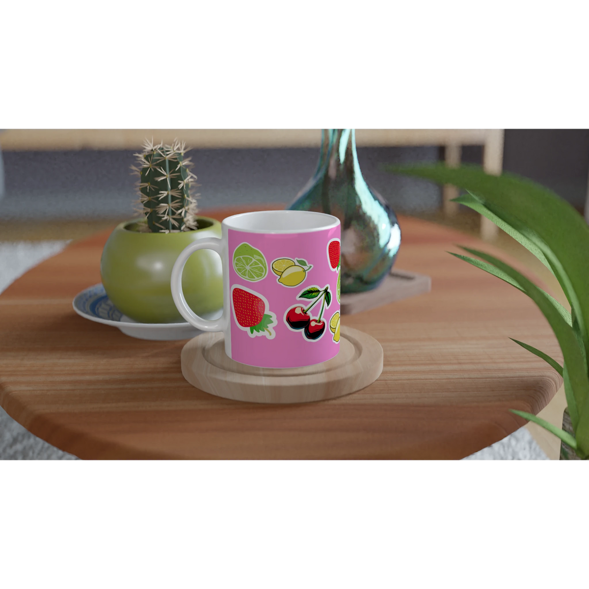 Pink ceramic mug featuring cute cherries, lemons, limes, and strawberries on a wooden table with a cactus.