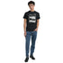 Male model in black mental health graphic T-shirt with bold white slogan, paired with blue jeans.