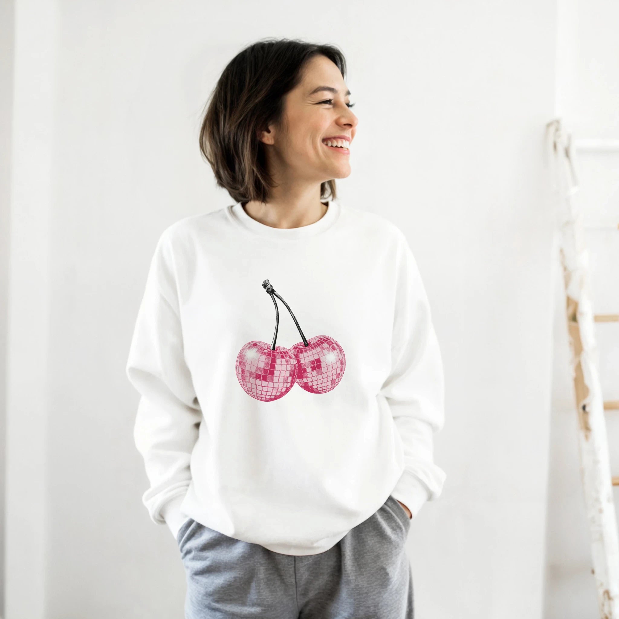 Pastel Y2K Cherries Sweatshirt with glitter pink cherry graphic, Urban Palm Trees, worn by a smiling woman.