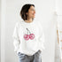 Pastel Y2K Cherries Sweatshirt with glitter pink cherry graphic, Urban Palm Trees, worn by a smiling woman.