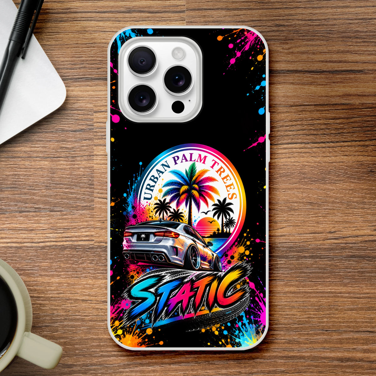 Static Slammed iPhone case featuring a lowered silver car, Urban Palm Trees sunset graphic, and colorful paint splatter art.