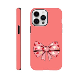 Pink tough iPhone case featuring a large coquette bow with red and white heart pattern on coral background.