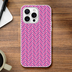 Pink geometric herringbone iPhone case with frosty transparent finish on wooden desk.