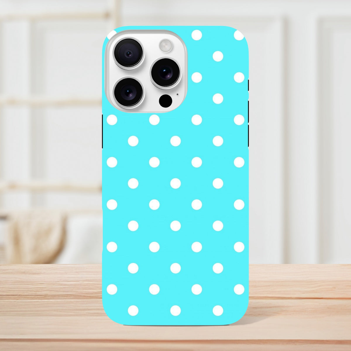 Turquoise and white polka dot tough iPhone case with retro style and drop protection on a wooden surface.