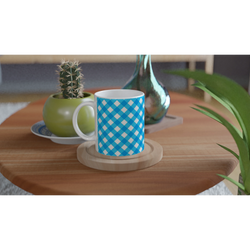 Blue gingham ceramic mug on a wooden table with a cactus and leafy greens nearby.