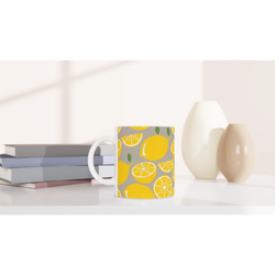 Cute lemon-patterned ceramic mug with yellow citrus slices, perfect for coffee or tea.