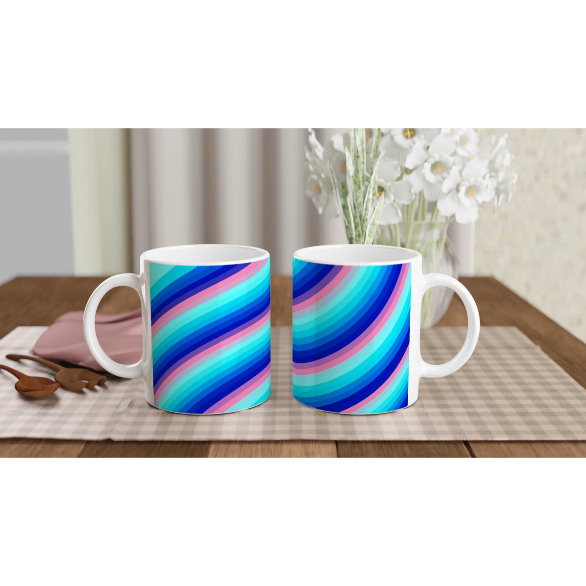 Two rainbow-striped ceramic mugs with blue, pink, and turquoise swirls on a table.