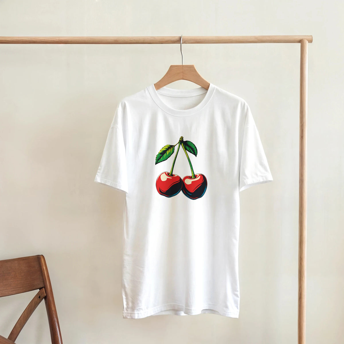 White retro cherry graphic t-shirt for women featuring a vintage fruit design on a wooden hanger.