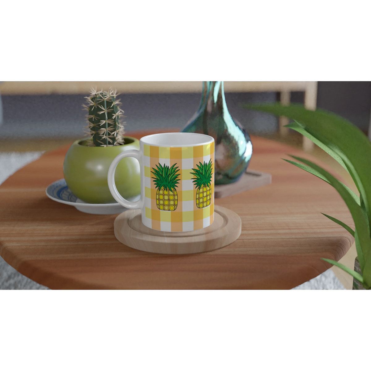 Pineapple-themed coffee mug with yellow gingham pattern on a wooden table beside a cactus.