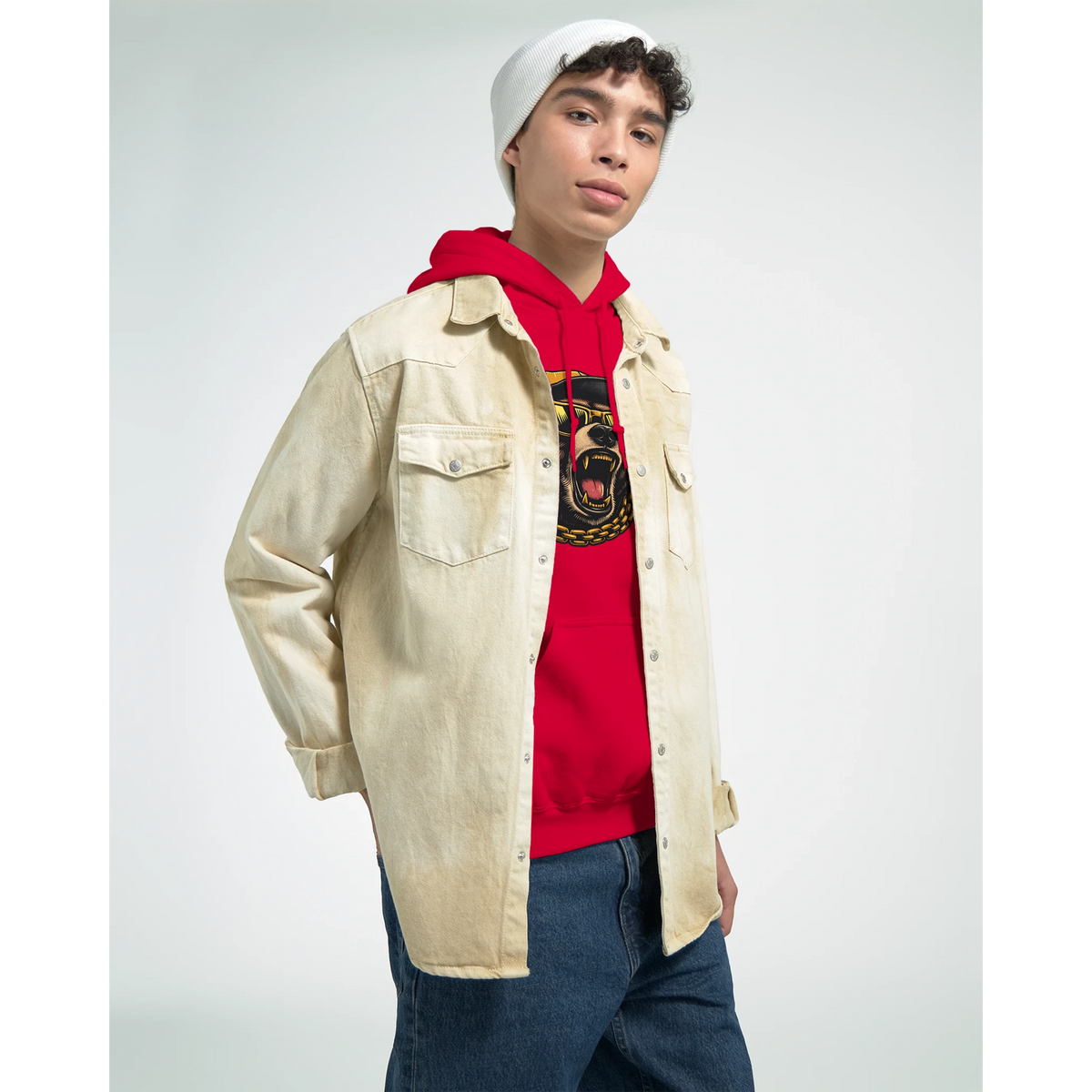 Man wearing Men's Grizzly Bear Hoodie in red over beige denim jacket with white beanie, studio portrait.