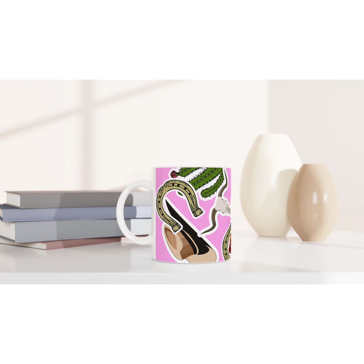 Pink western ceramic coffee mug featuring cowboy boots, cactus, and horseshoe illustration on a vibrant pink background.