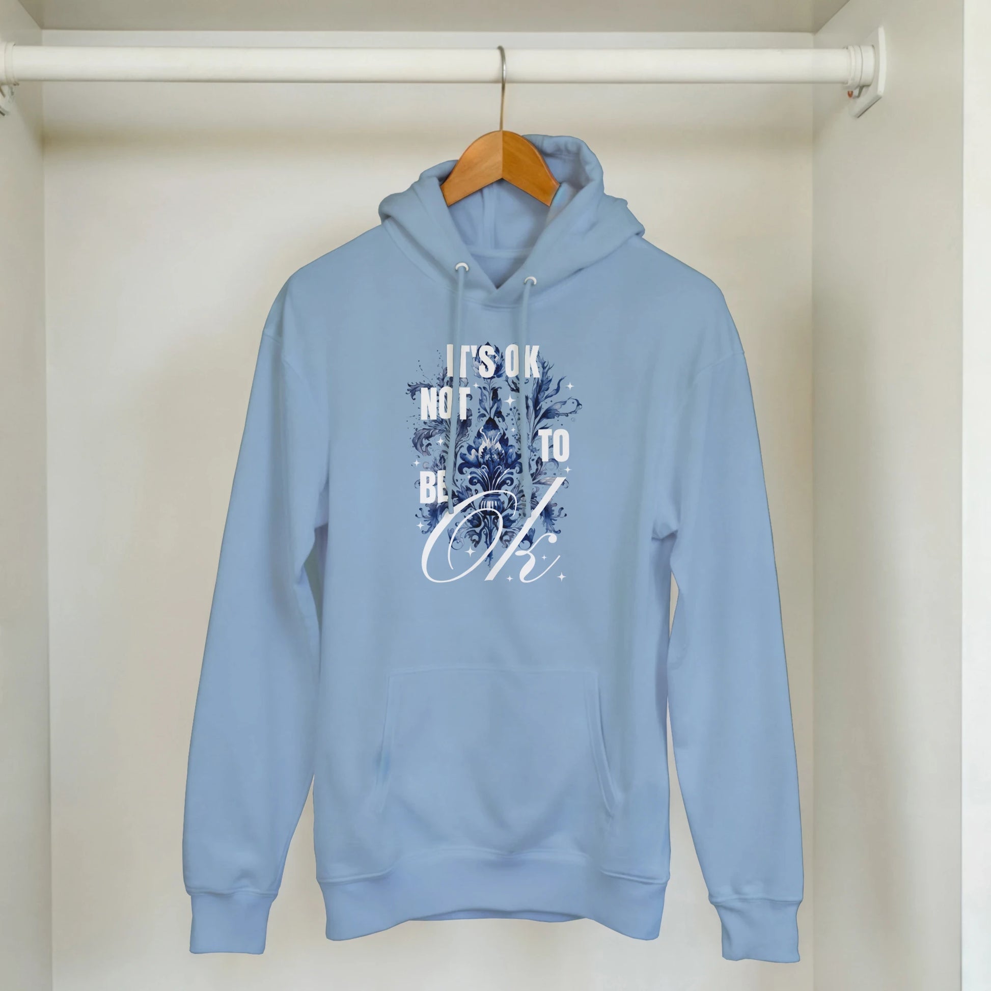 Light blue cotton-poly hoodie with 'It's OK Not To Be OK' graphic and floral artwork, front pouch pocket.