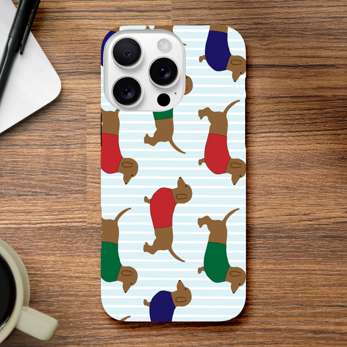 Cute durable iPhone case featuring playful dachshunds in colorful sweaters on a light blue striped background.