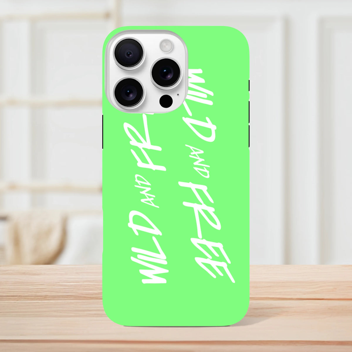 Lime green iPhone case featuring white "Wild and Free" Y2K handwritten text and shock-absorbing tough protection.
