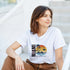 Woman wearing a white Miami graphic T-shirt featuring a tropical sunset palm scene on a soft cotton-blend tee.