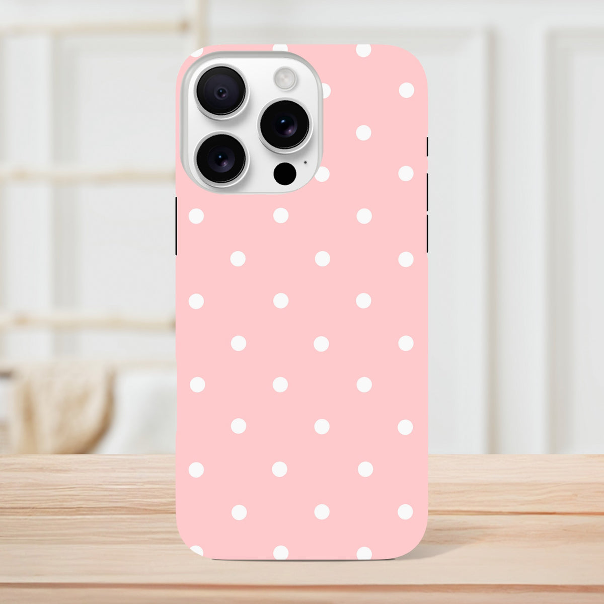 Pastel pink iPhone case with white polka dots. Cute tough dual-layer cover designed for drop protection on iPhone 13-16 models.