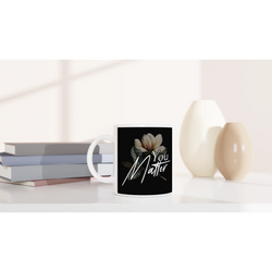 White ceramic mug featuring a black label with the You Matter slogan and a floral illustration.