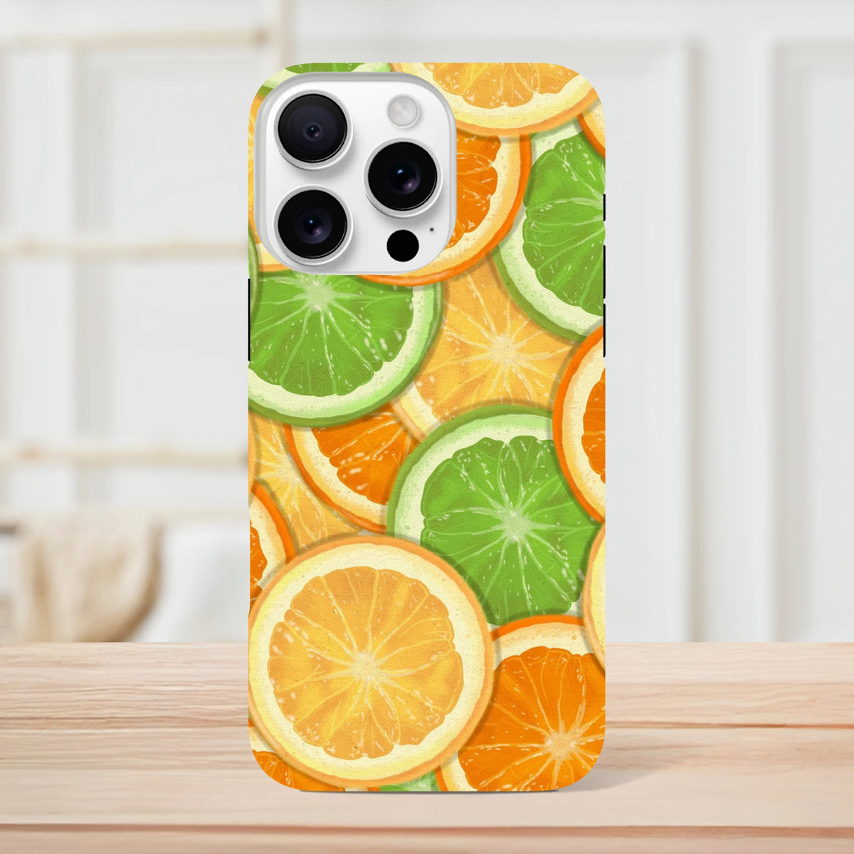 Tough iPhone case featuring a vibrant wraparound print of sliced oranges and limes for models 13-16.